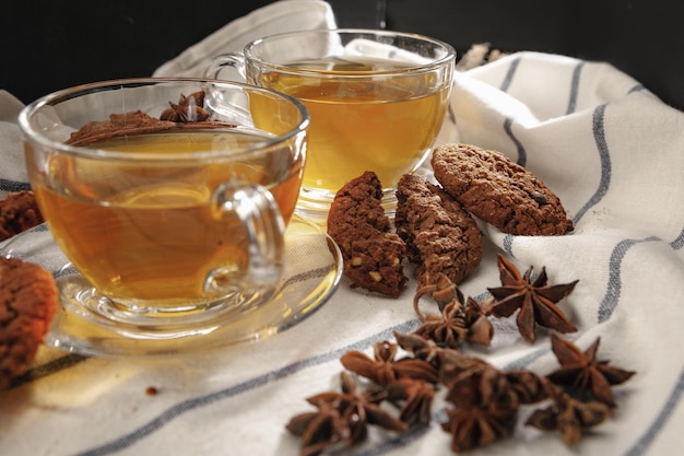 Two cups of herbal tea and cookies on kitchen cloth