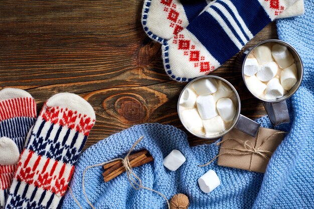 Due tazze di cioccolata calda o cioccolata con guanti marshmallow decorazioni natalizie e abete su legno...