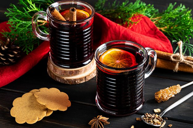 Two cups of hot mulled wine on a dark wooden background