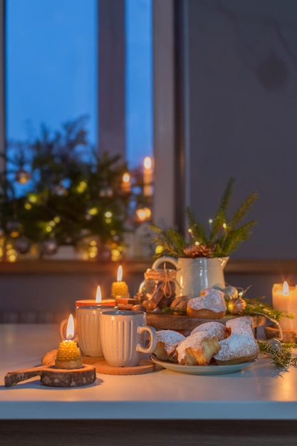 Фото Две чашки чая с домашней рождественской выпечкой на кухне с рождественскими украшениями