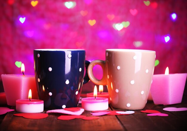 Two cups on table on lights background