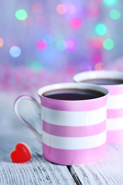 Two cups on table on lights background