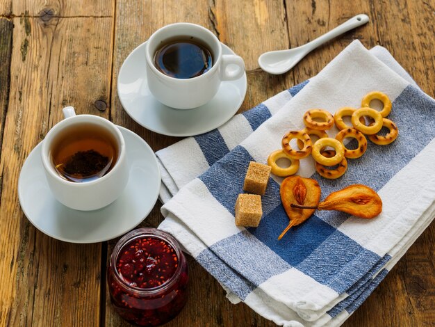 Two cups of tea and bagels on a wooden table