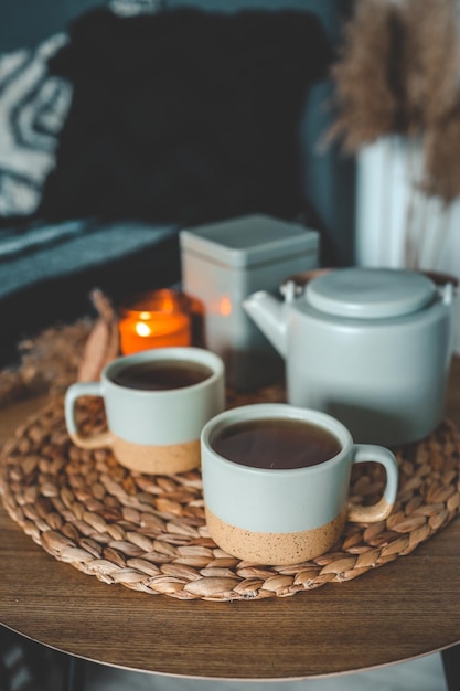 2杯のお茶、やかん、寝室の家の内部に燃えるろうそく