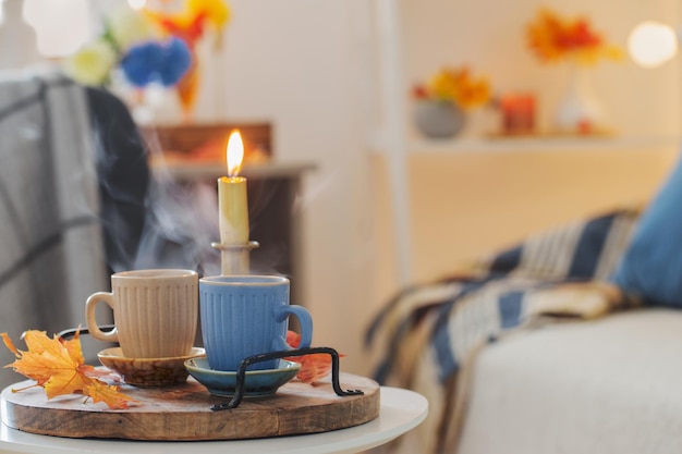 Two cups with hot drinks at home with autumnal decor