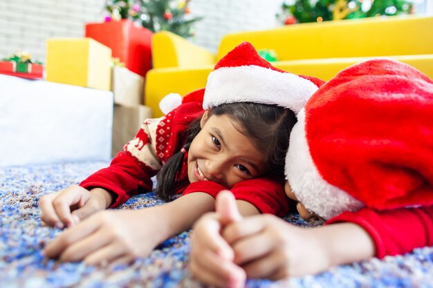 Two cute asian child girls laying down on the floor and play together in Christmas celebration