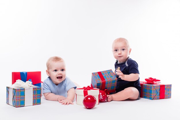 Two cute baby sitting on white 