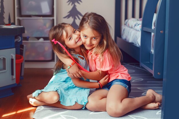 Photo two cute caucasian girls siblings hugging together happy smiling friends family relationship