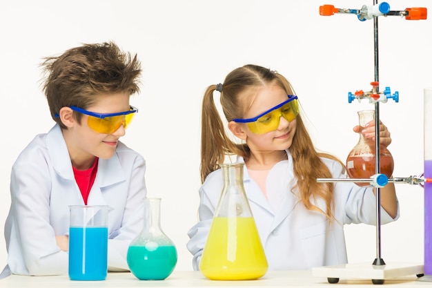 흰색 바탕에 실험을 하는 화학 수업에서 두 명의 귀여운 아이들