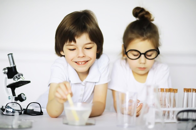 白い背景で隔離の実験を作る化学のレッスンで2人のかわいい子供たち