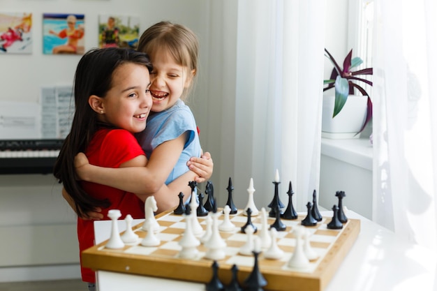 Two cute children playing chess at home