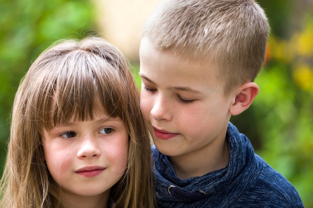 写真 2人のかわいい金髪の子供兄弟、明るい日当たりの良い緑のボケの屋外で若い男の子の兄と妹の女の子。