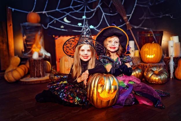 Due simpatiche sorelle divertenti celebrano la festa. bambini allegri in costumi di carnevale pronti per halloween.