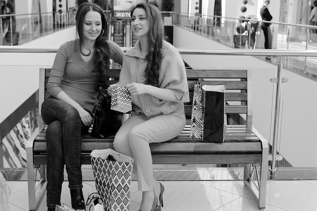 Due ragazze carine vanno a fare shopping nel centro commerciale