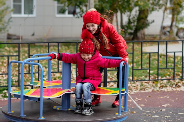 Two cute girls ride a swing Childhood Autumn