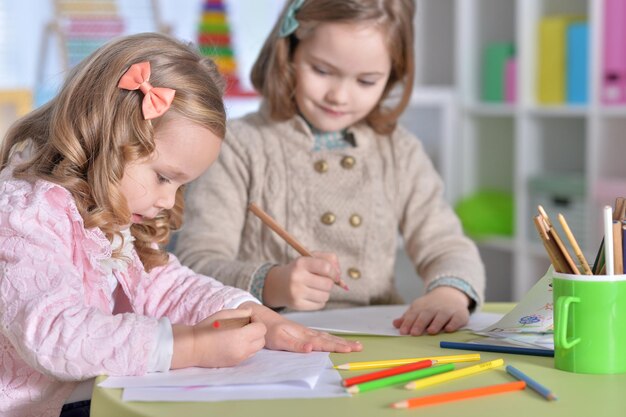 Two cute little girls drawing