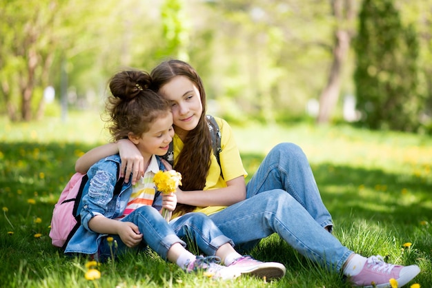 Two cute sisters' girls on a walk It's spring outside and the sun is bright