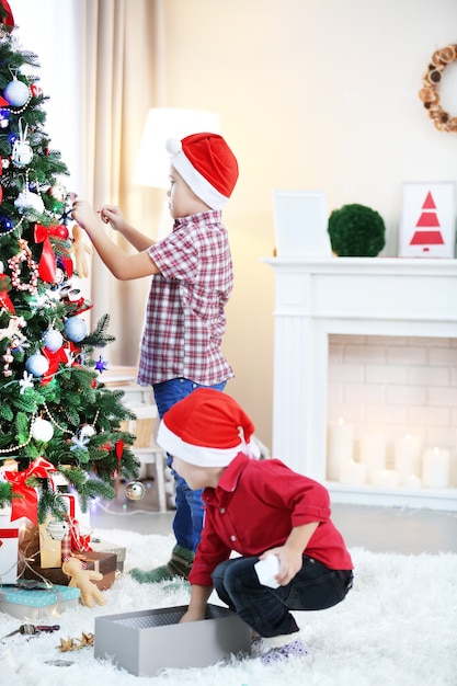 Two cute small brothers decorating Christmas tree