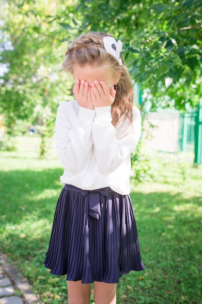 Due bambine smilling svegli che posano davanti alla loro scuola.