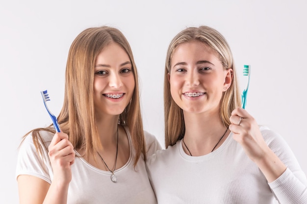 Two cute teenagers with a dental braces they have toothbrushes in their hands