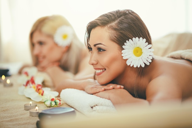 Two cute young women are enjoying during a skin care treatment at a spa.