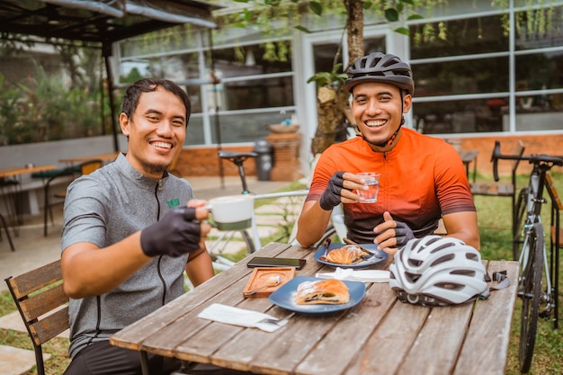 Two cyclist enjoying coffee in the cafe after riding