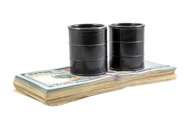 Two decorative black fuel oil barrel with heap of US dollar bills on white Business concept