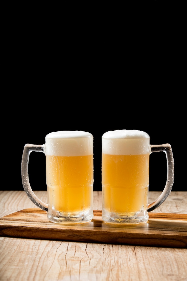 Photo 木製のテーブルに2つのおいしいドラフトビールジョッキ