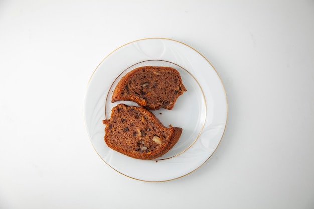 Two delicious slices of homemade carrot, hazelnut and cocoa cake on a gold plated porcelain plate.