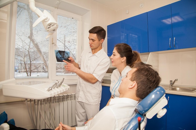 Two Dental Doctors Discussing a Complicated Case of a Patient with Teeth XRay