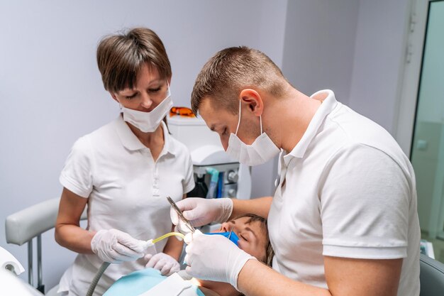 Two dentists examine the patient's teeth for the further treatment Modern stomatology cabinet