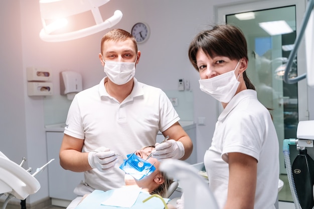 Two dentists examine the patient's teeth for the further treatment