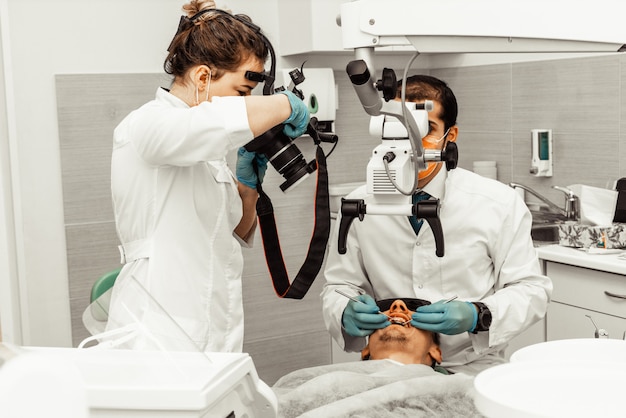 Two dentists treat a patient. Professional uniform and equipment of a dentist. Healthcare Equipping a doctor's workplace. Dentistry