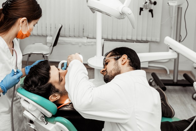 Two dentists treat a patient. Professional uniform and equipment of a dentist. Healthcare Equipping a doctor's workplace. Dentistry