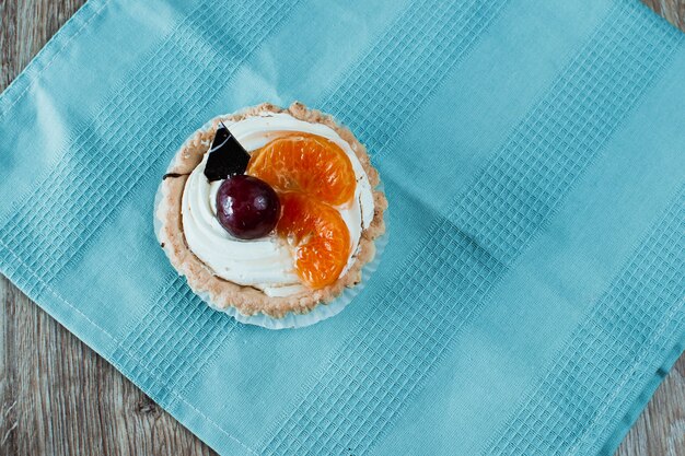 Two desserts, one chocolate with cherries, the other white cream with plums and tangerines