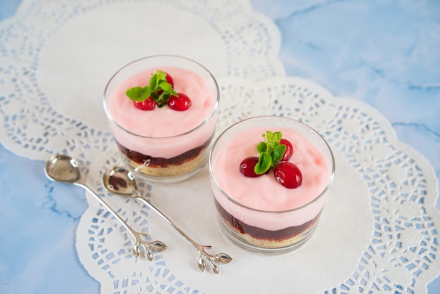 two desserts with cranberries in glass glasses