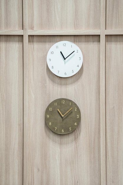 Photo two difference clocks hang on to wooden background