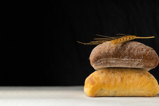 Foto due diversi pani di segale e grano su sfondo nero