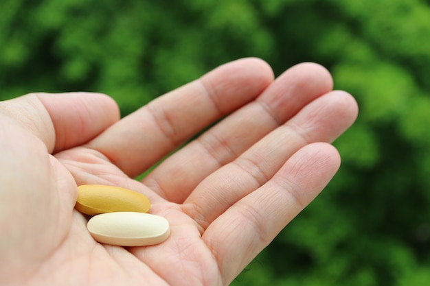 Two Different Color Supplement Tablets in Man's Palm