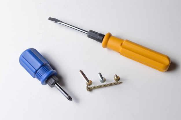 Two different screwdrivers and several screws 