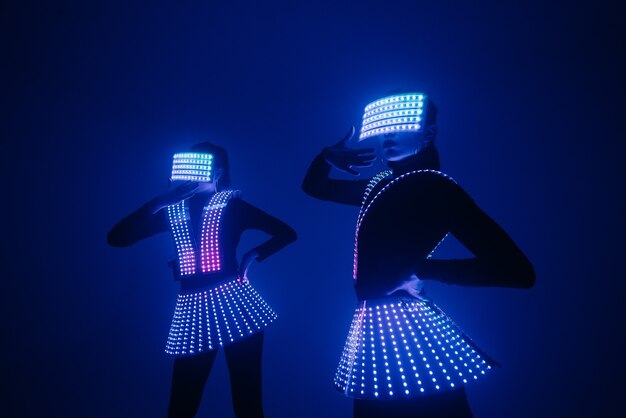 Two disco dancers move in UV costumes. 