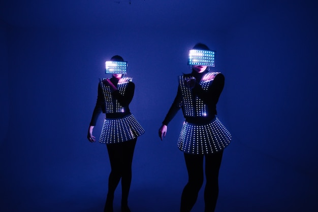 두 명의 디스코 댄서가 UV 의상을 입고 움직입니다.