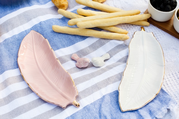 Two dishes in feather form on blue blanket