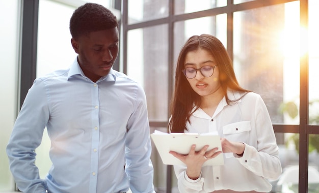 Two diverse colleagues have small talk during break