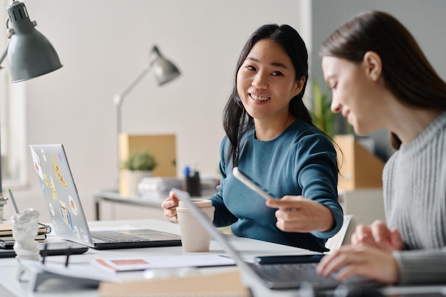 Photo two diverse women working in office