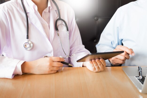 Due medici che discutono le note pazienti in un ufficio che indica un ridurre in pani