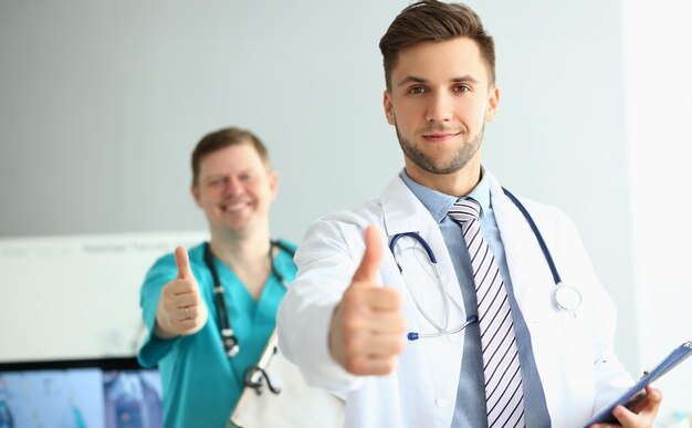 2人の医師が診療所で親指を挙げて医療サービスを推奨している