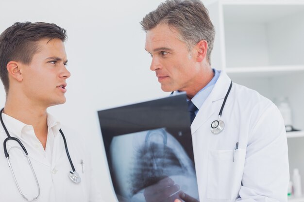 Two doctors holding and analysing an xray