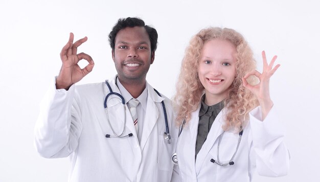 Два врача медицинского центра показывают жест ОК