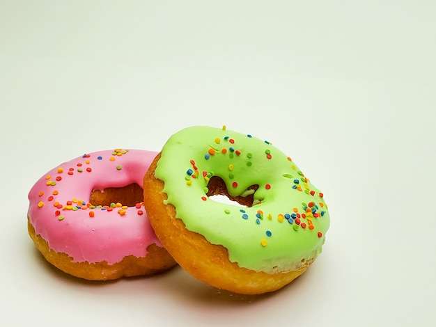 Two donuts for Breakfast on isolated white wall